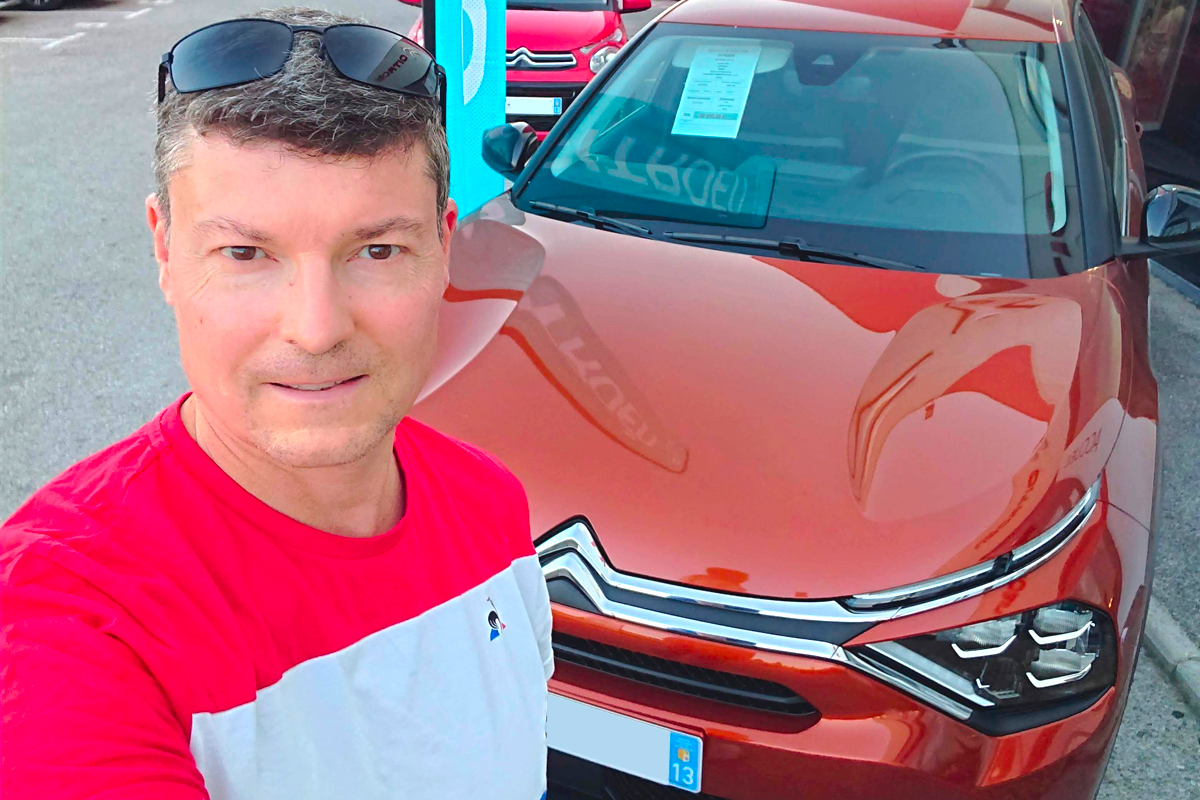 Thierry en tee-shirt bleu-blanc-rouge devant la Citroën ë-C4 encore en vente